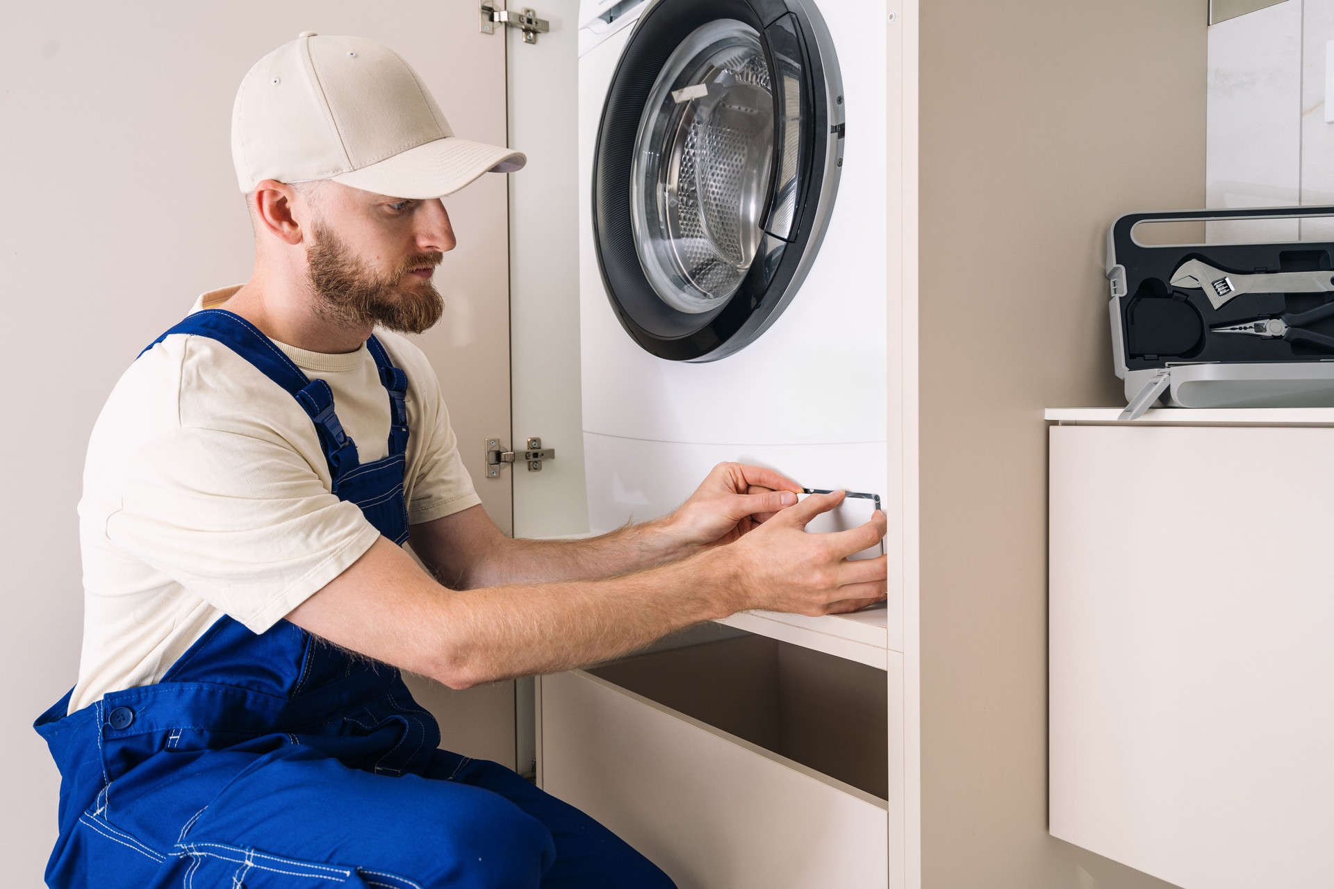 Man installs automatic washing machine in modern laundry room with efficient design